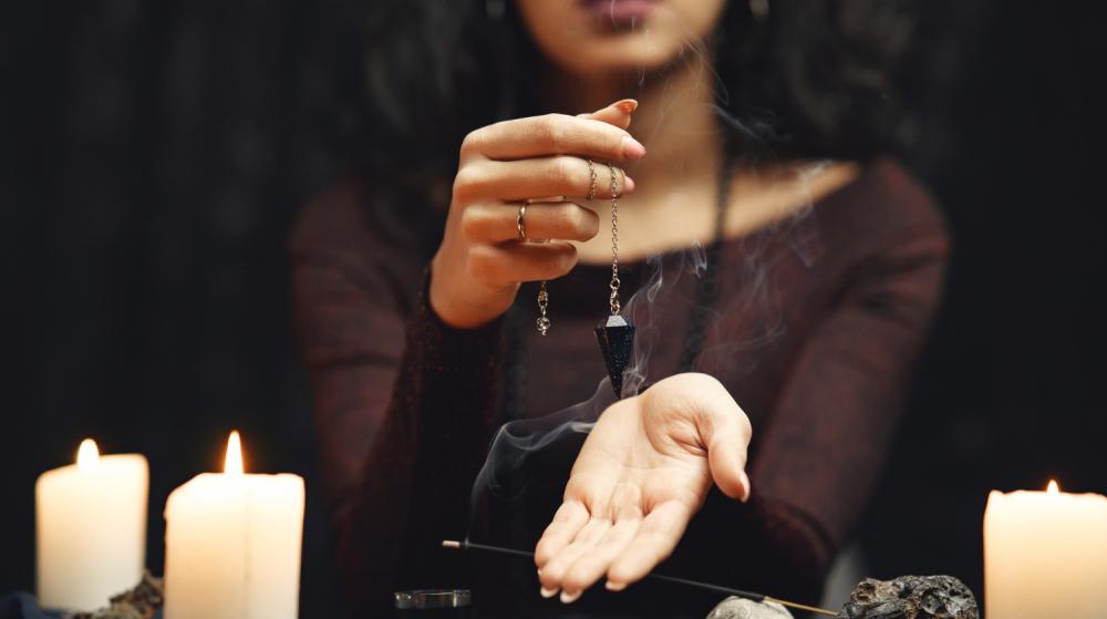 wróżka z wahadełkiem i świecami