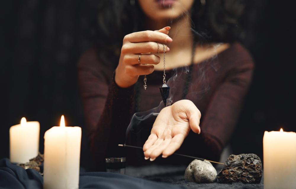 wróżka z wahadełkiem i świecami