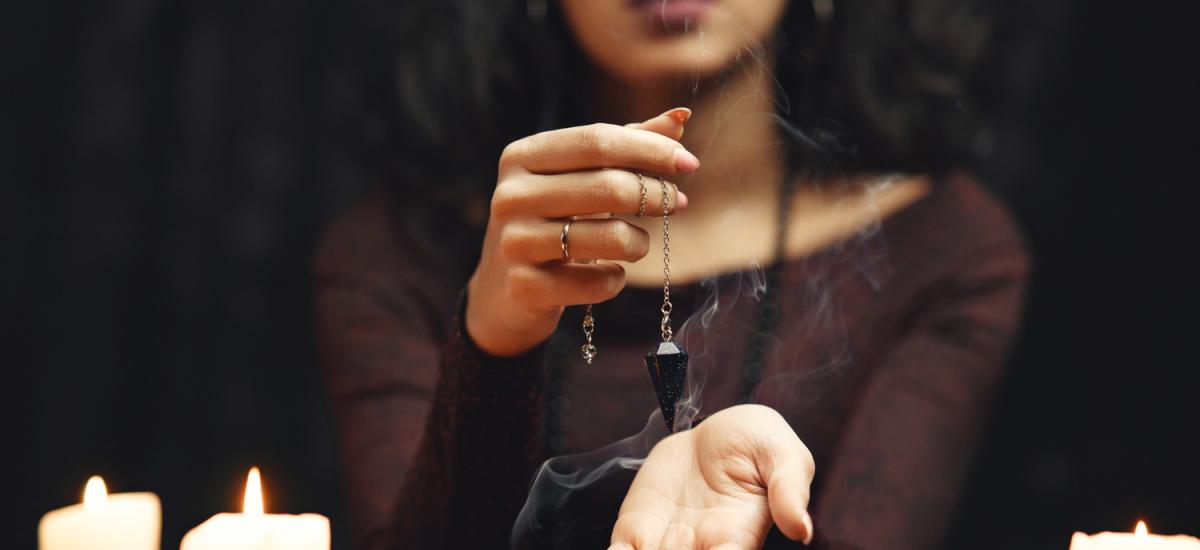 wróżka z wahadełkiem i świecami