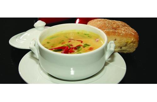 Zupa z papryką i ziołami w białej miseczce, podana z bułką