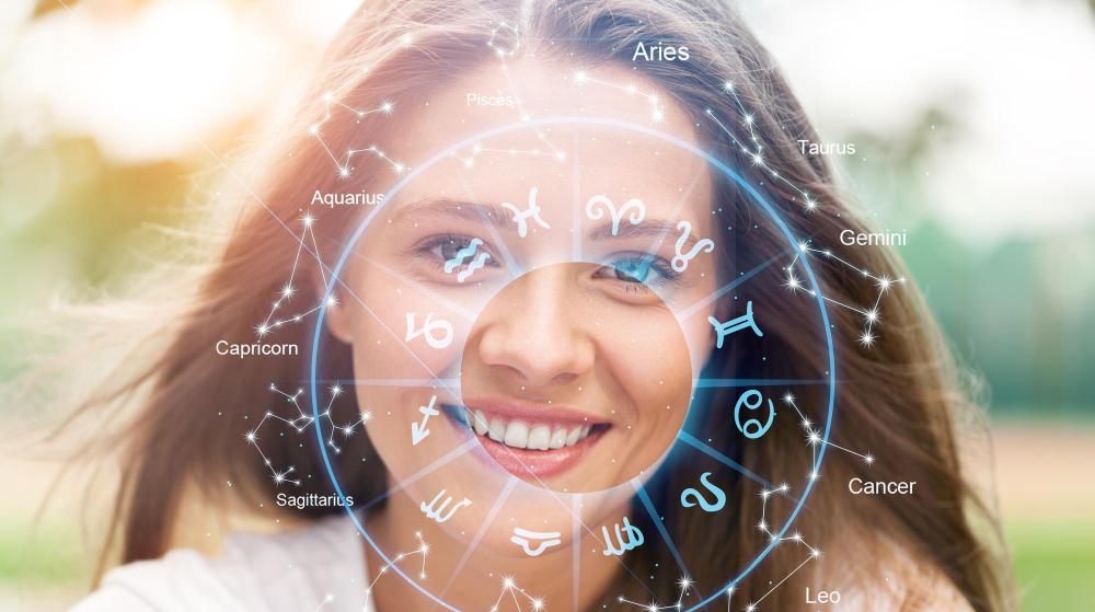 Uśmiechnięta kobieta na tle koła zodiaku i gwiazdozbiorów