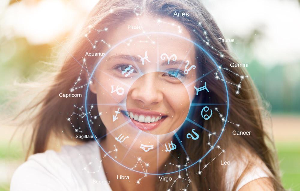 Uśmiechnięta kobieta na tle koła zodiaku i gwiazdozbiorów