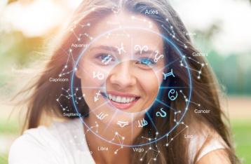 Uśmiechnięta kobieta na tle koła zodiaku i gwiazdozbiorów